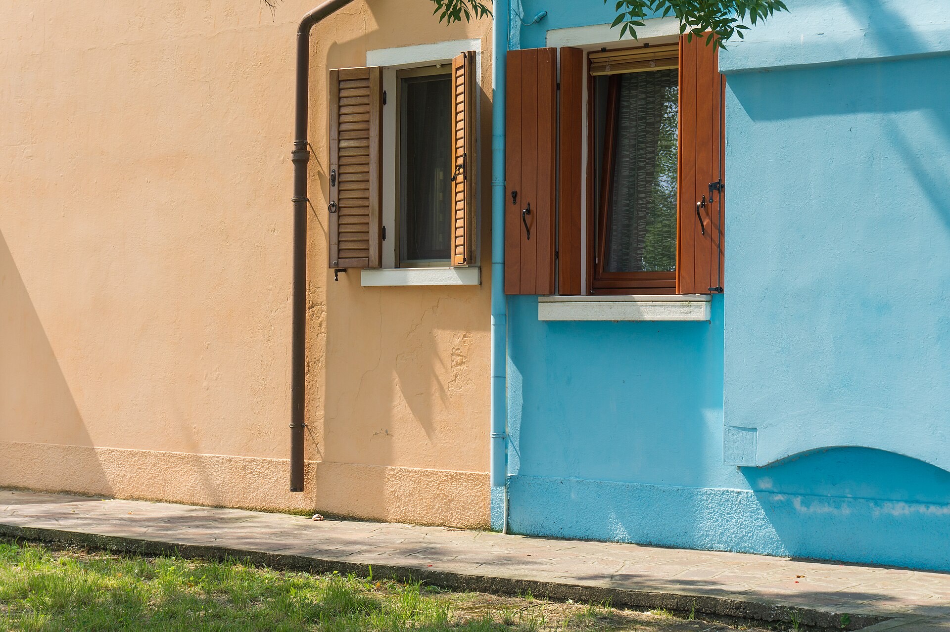 Two neighbouring houses on Burano painted in complementary colours